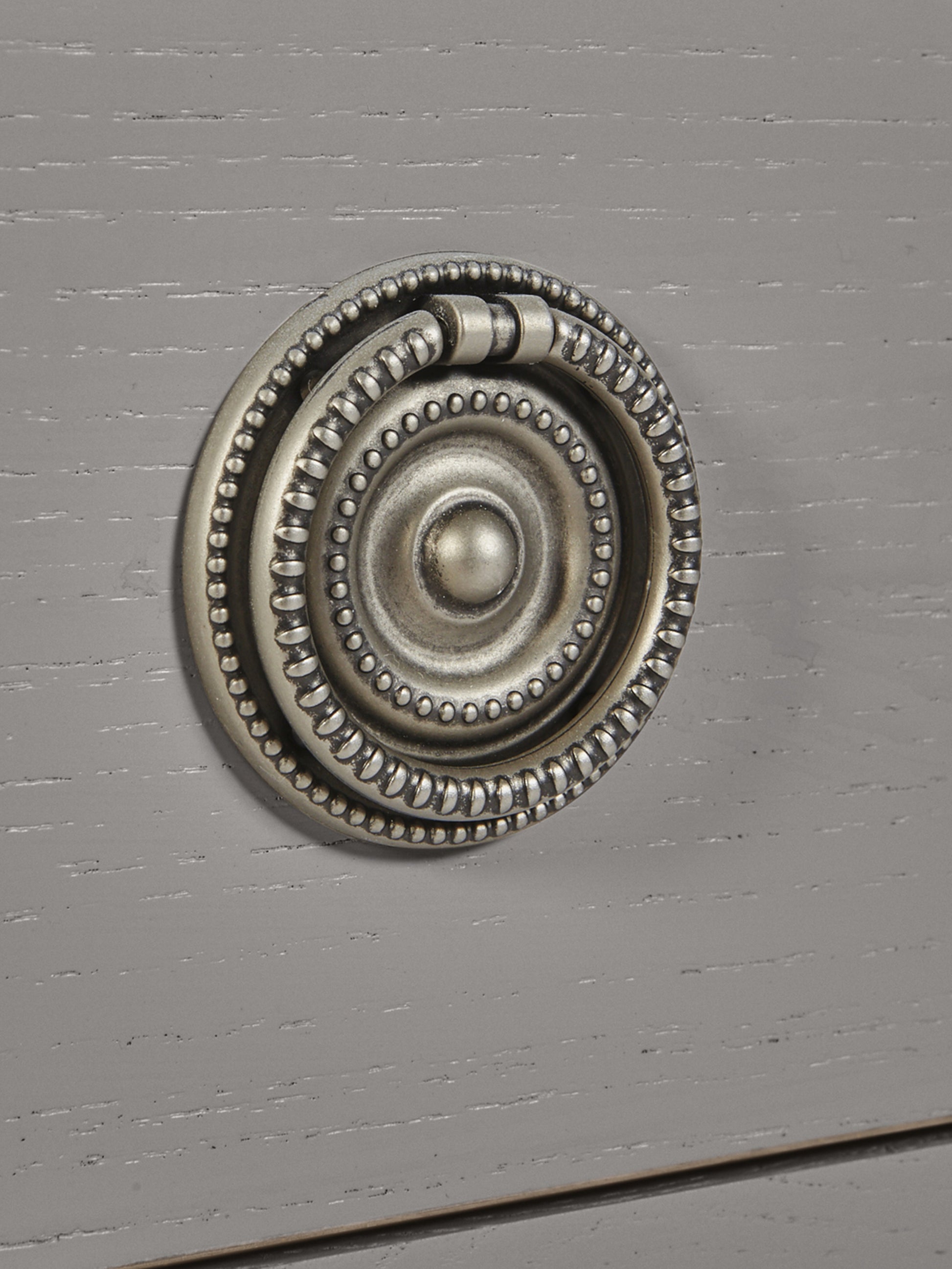 Decorative metal knob on a gray cabinet door
