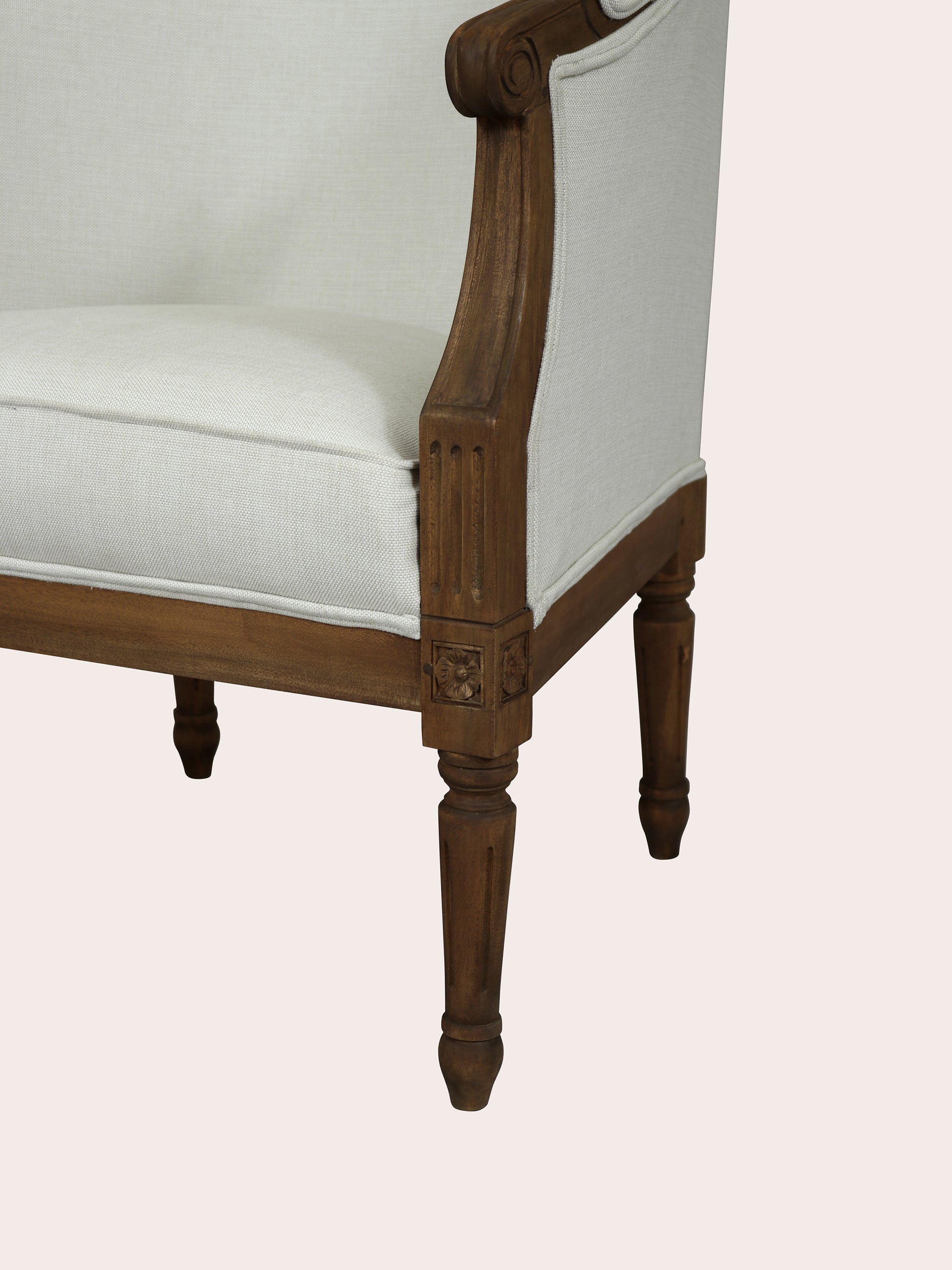 Chair with wooden frame and white cushion on a light pink background
