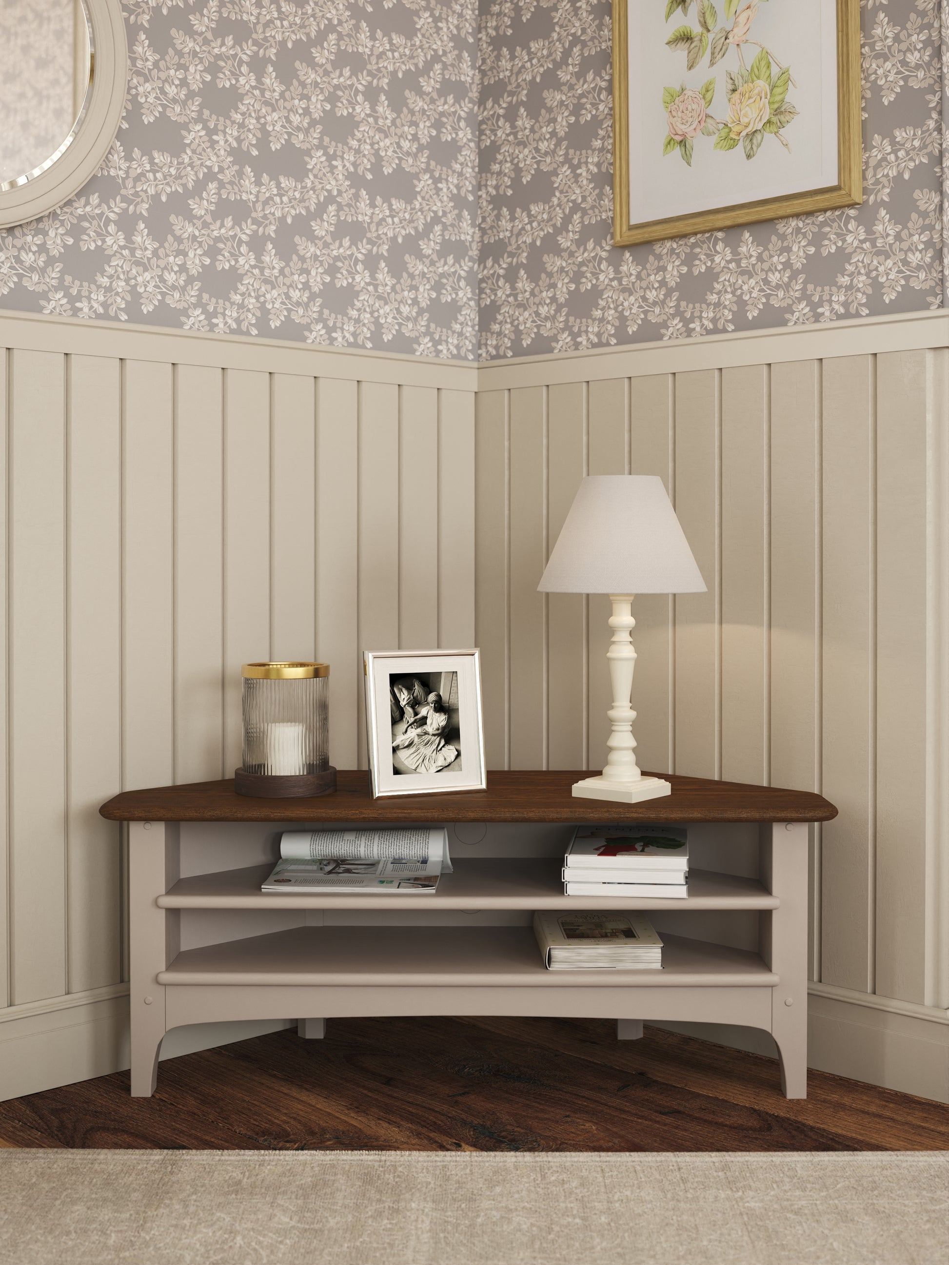 Wooden corner TV stand with decorative items against a floral wallpapered wall.