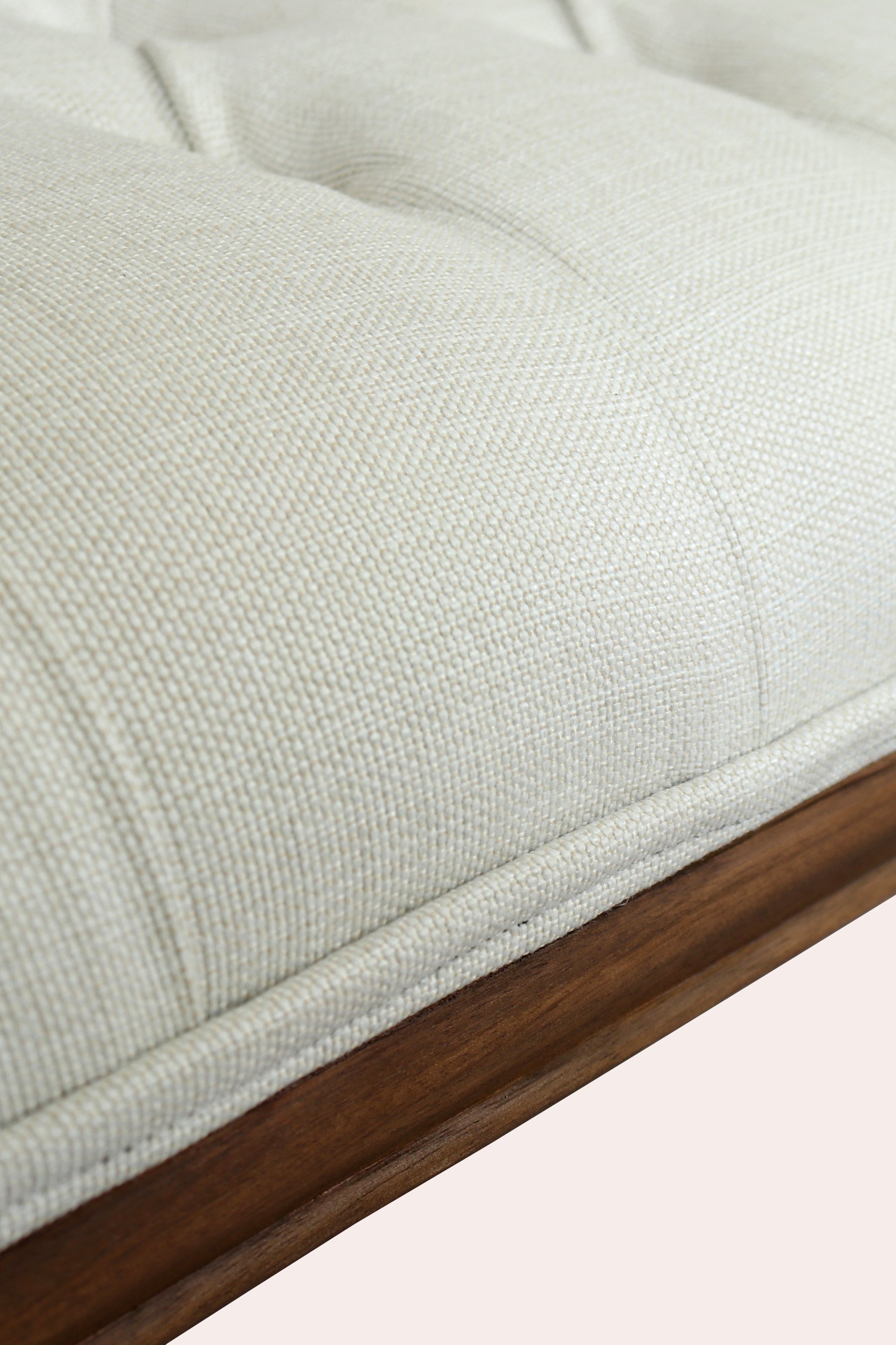 Close-up of a textured light gray cushion with a wooden border on a white background