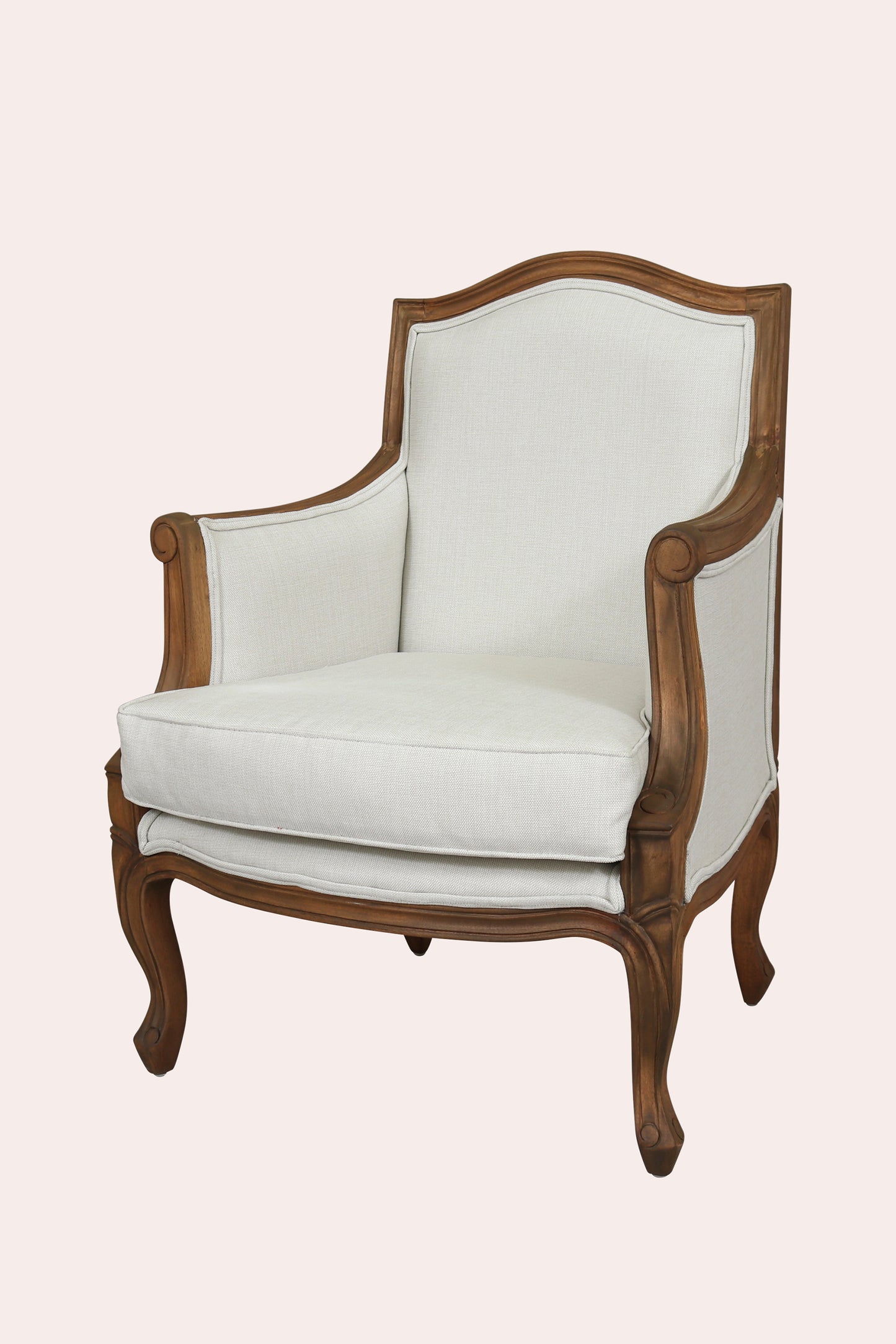 White upholstered armchair with wooden frame on a light pink background