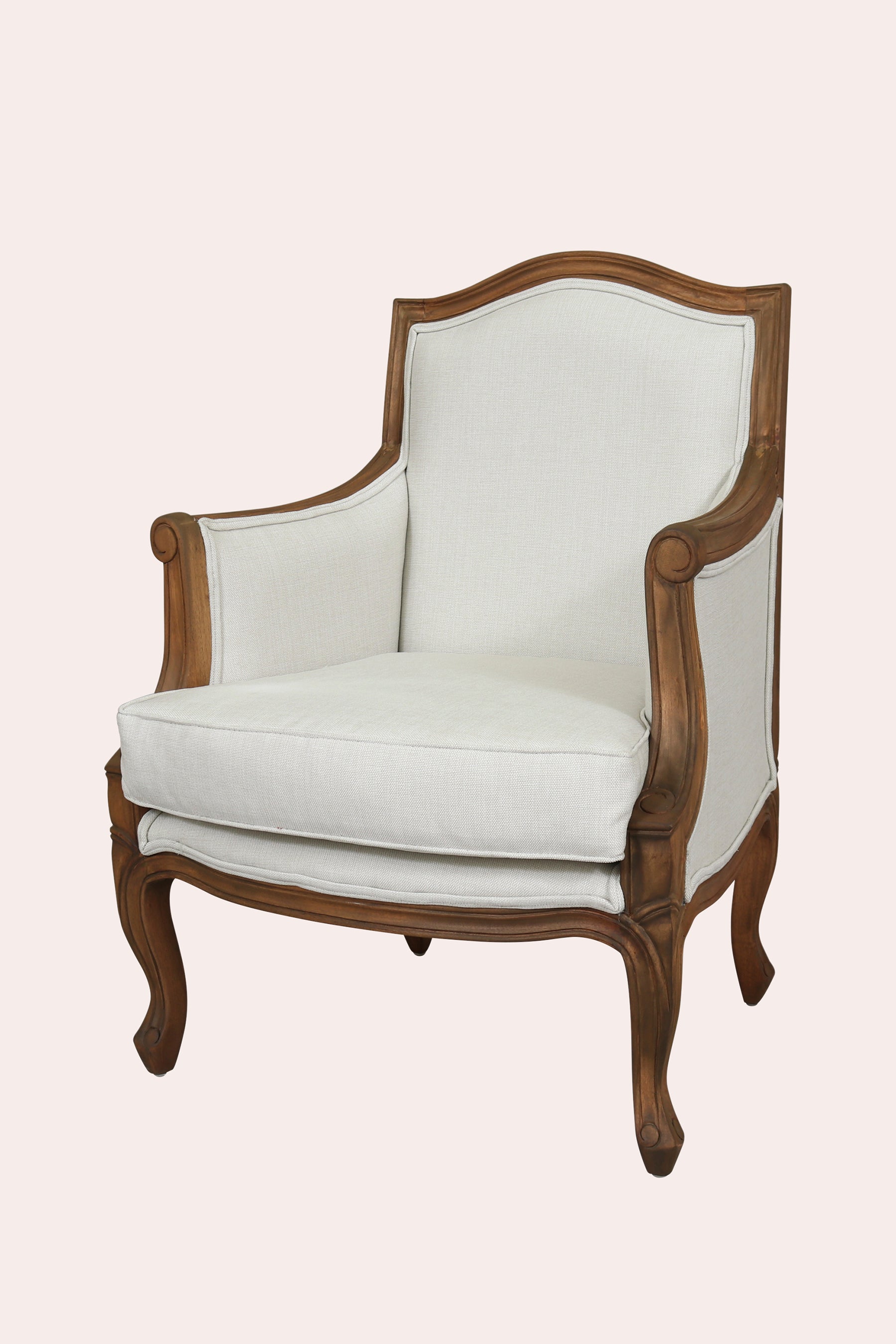 White upholstered armchair with wooden frame on a light pink background