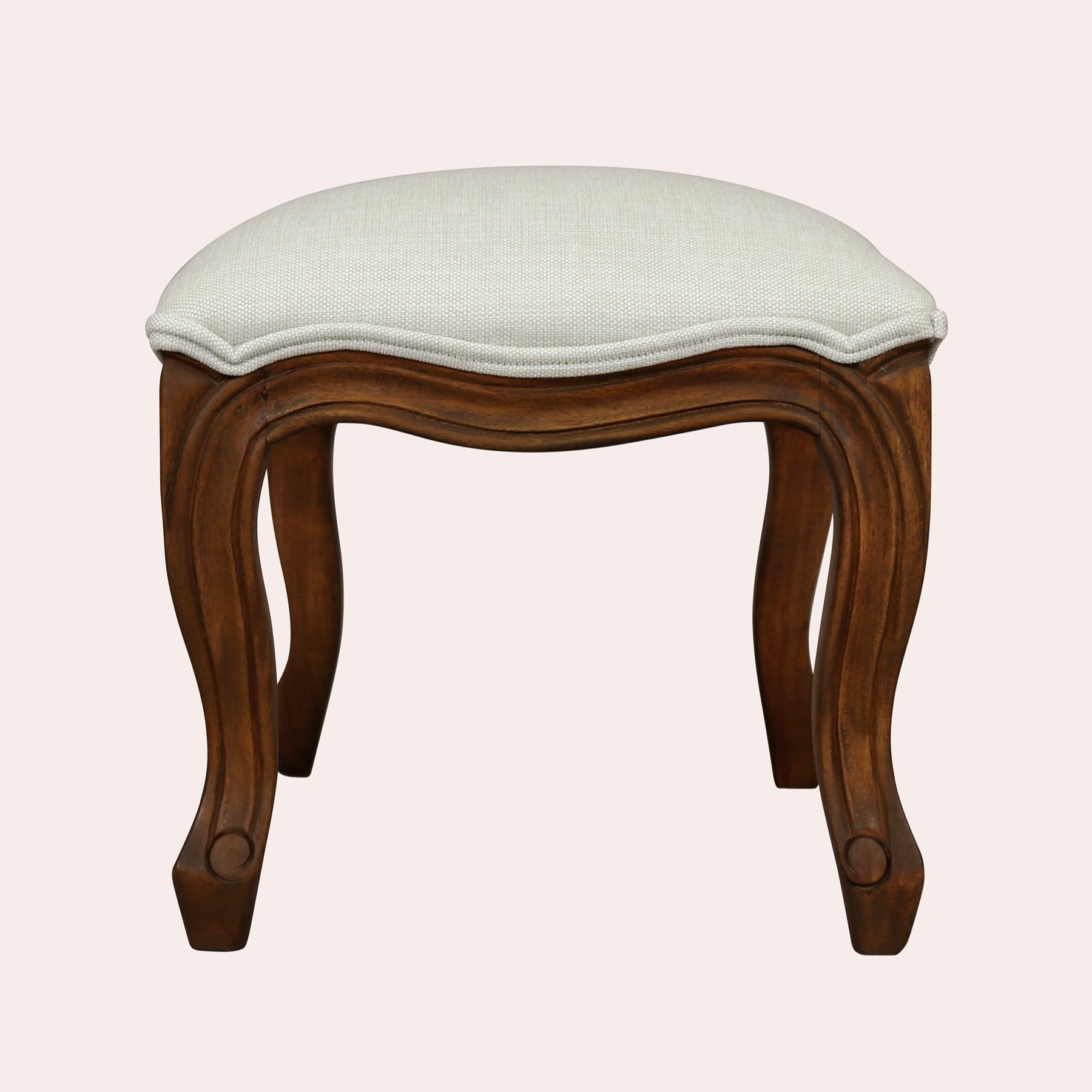 Wooden stool with a white cushion on a light pink background