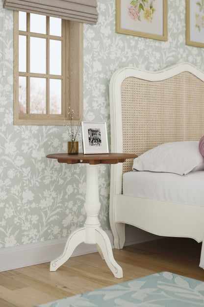 Bedroom corner with a bed, side table, and floral wallpaper.