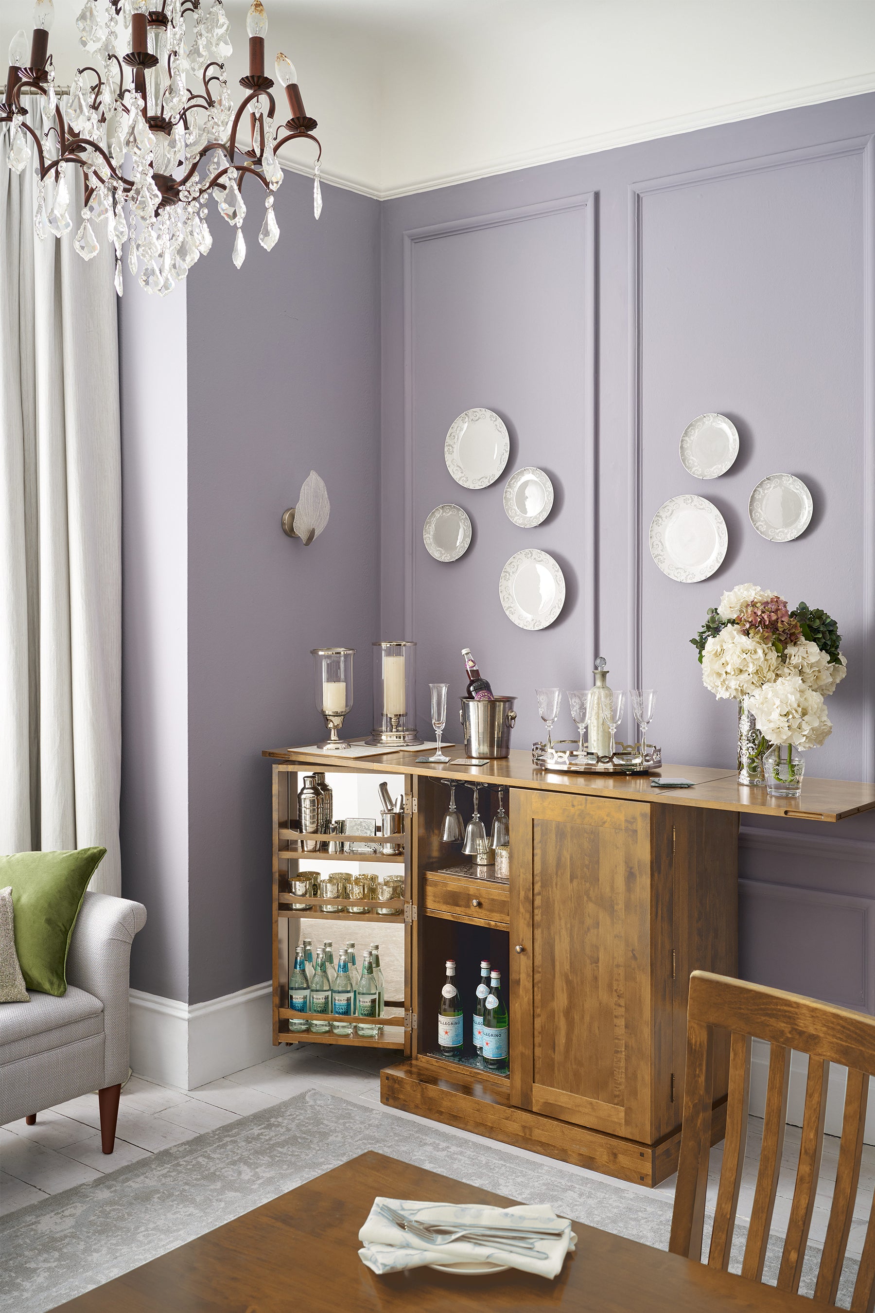 Dining room with wooden bar cart and purple walls featuring drinks cabinet showing both the outside and the interior