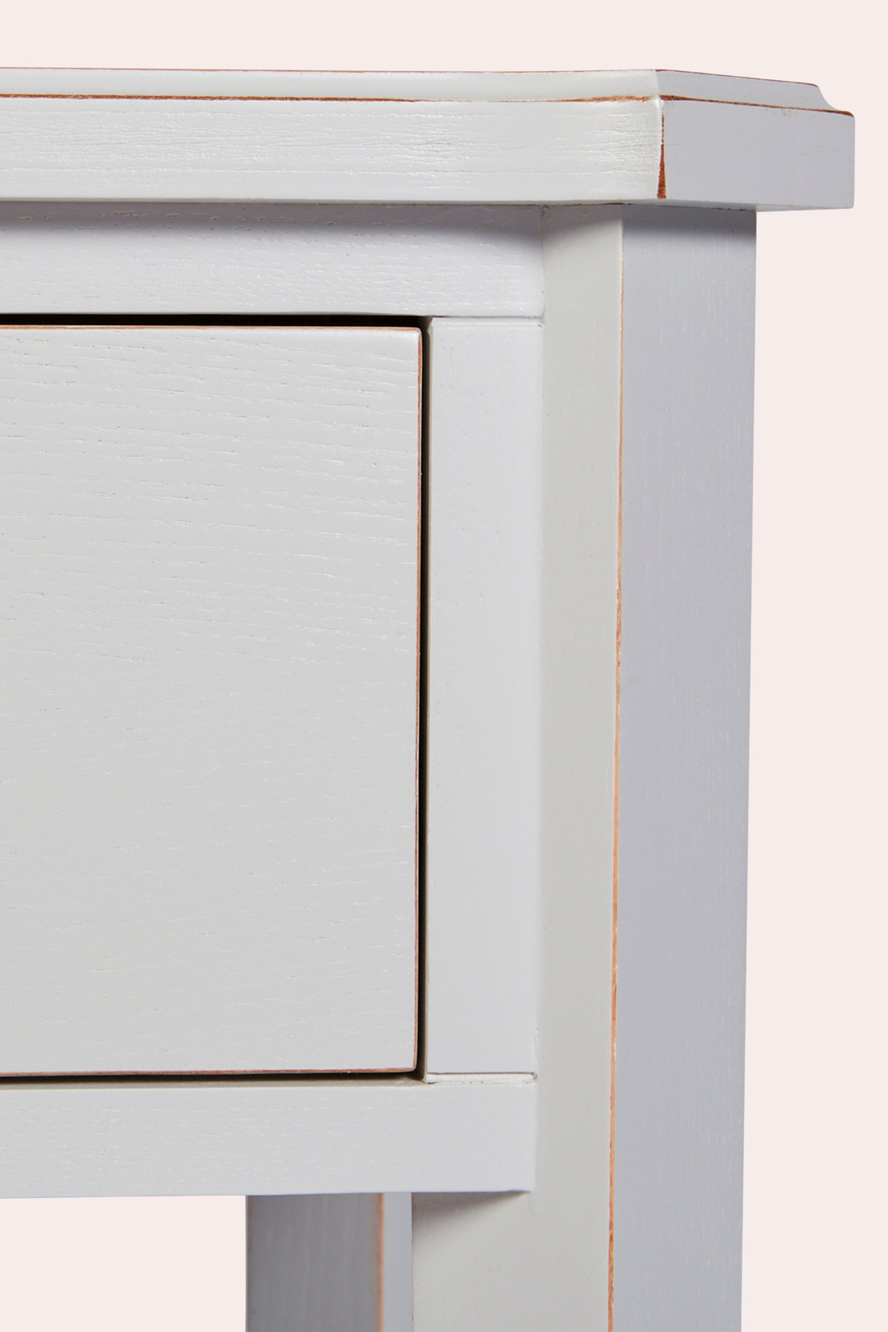 Close-up of a light gray wooden side table with a drawer.