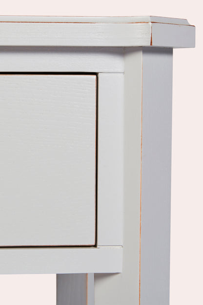 Close-up of a light gray wooden side table with a drawer.