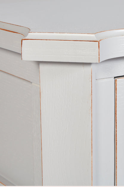 Close-up of a white cabinet with decorative molding on a light gray background