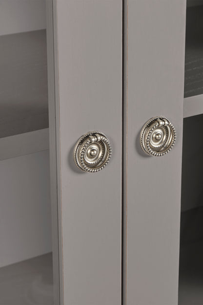 Close-up of a gray cabinet with decorative silver knobs.