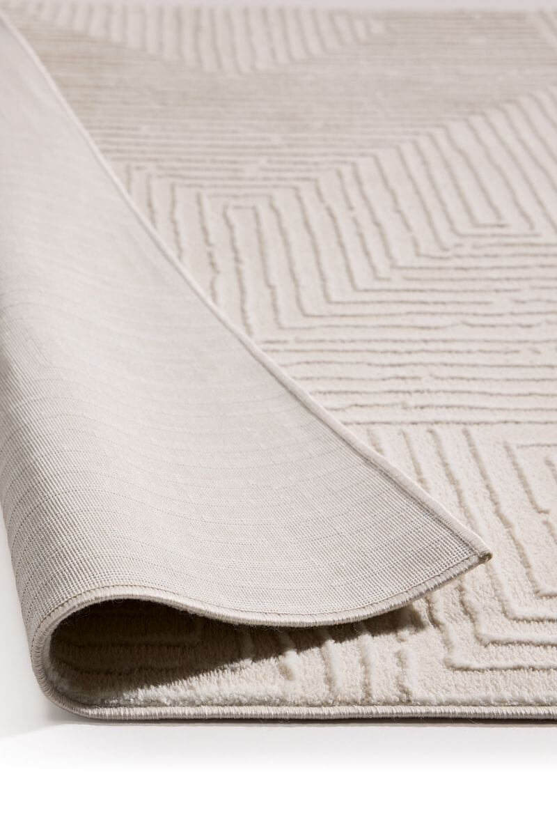Close-up of a textured beige rug with geometric pattern on a white background