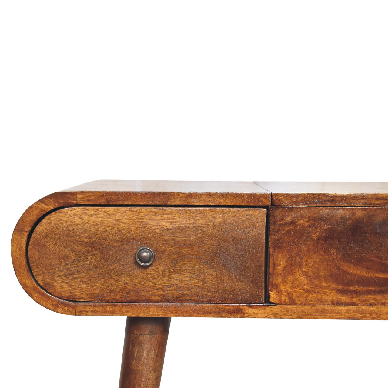 Close-up of the rounded corner edge of a wooden dressing table with a smooth finish and visible grain.