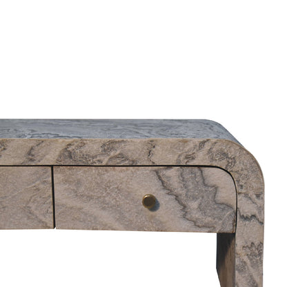 Close-up of the corner of a marble-effect coffee table, focusing on the smooth rounded edge and stone-like pattern.
