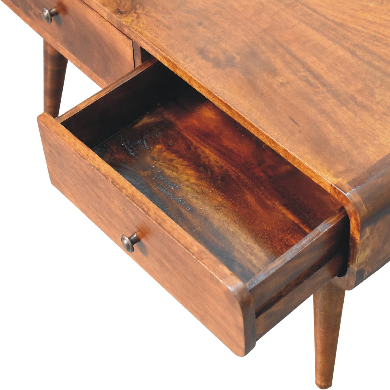 Close-up of the tabletop surface with rich walnut-toned wood grain with 1 open drawer with rounded brass knobs and neatly framed fronts.