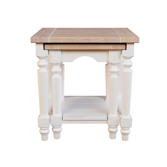 A white and brown nest of two tables with a wooden top and carved legs.