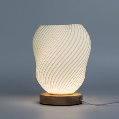 Decorative table lamp with ribbed design and wooden base on a gray background