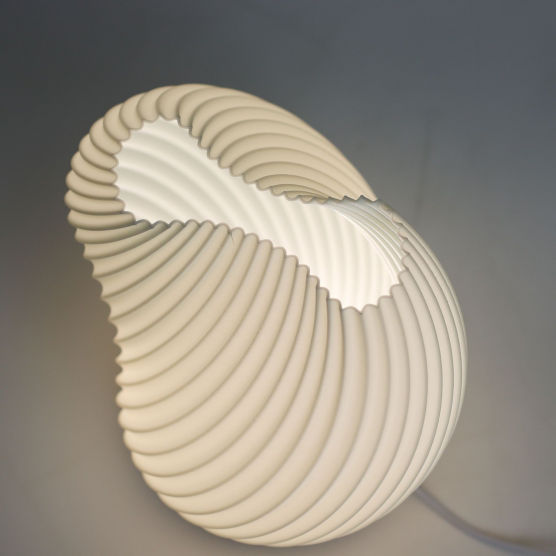 Modern table lamp with a shell-like design on a dark background