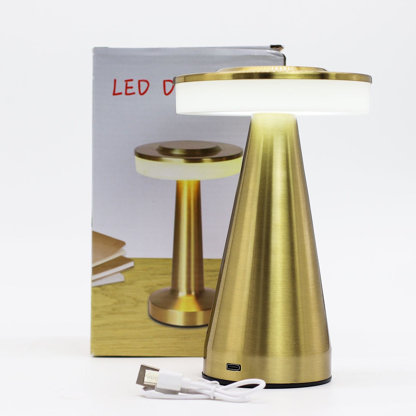 Gold table touch lamp with white shade and USB cable in front of packaging box on a white background