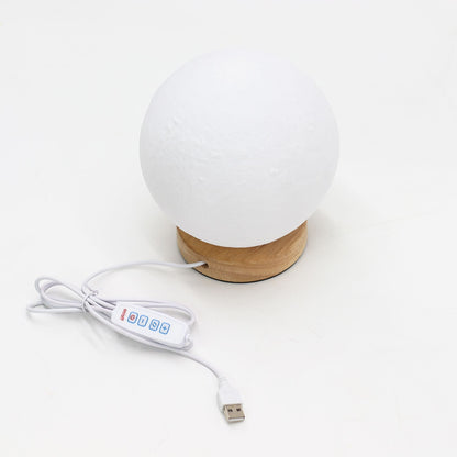 White spherical lamp with wooden base and USB cable on a white background
