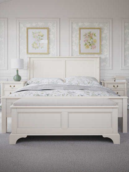 White wooden bed with floral decorations on the wall