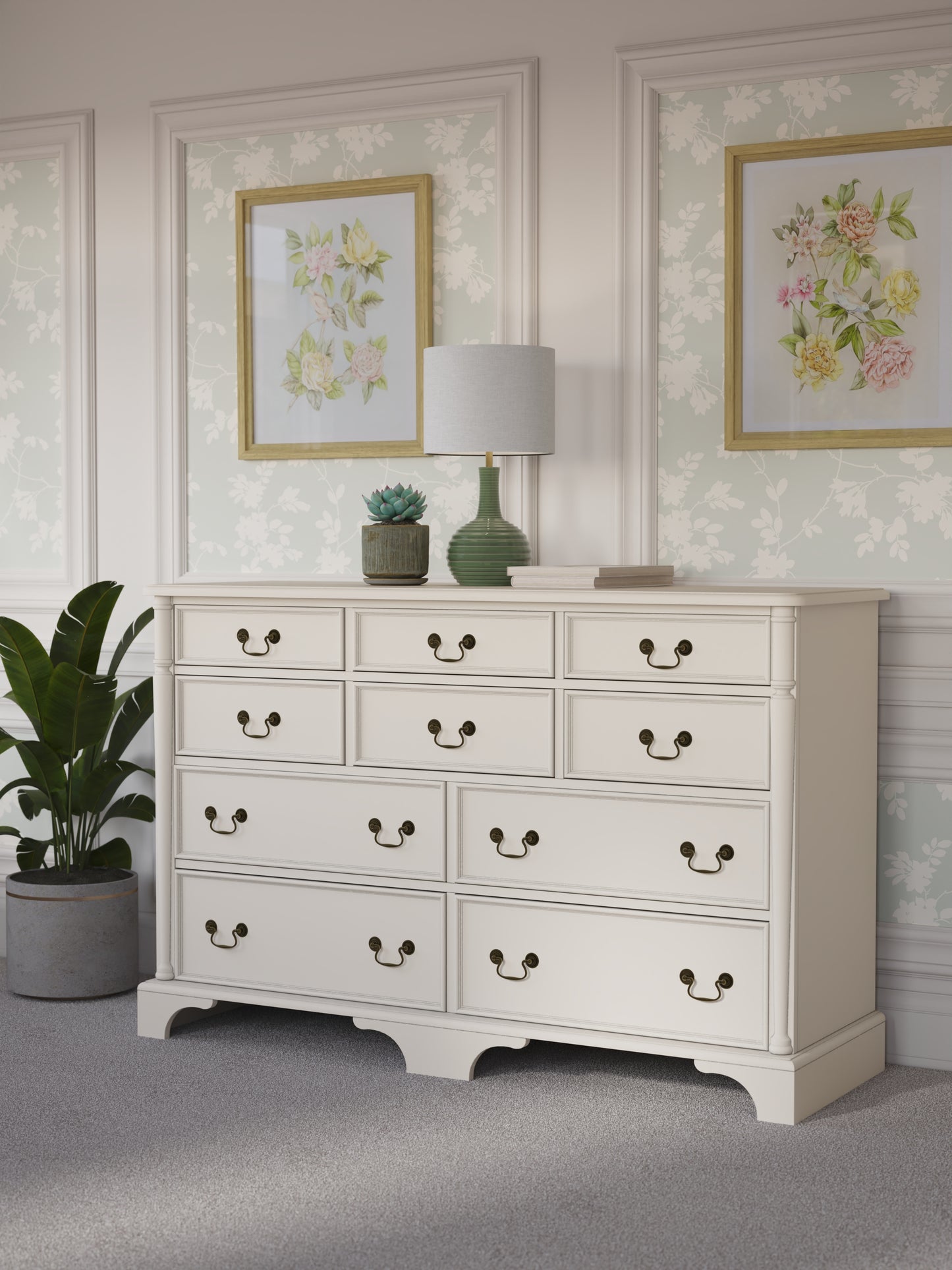 Ivory white dresser with multiple drawers in a room decorated with floral artwork and a plant.