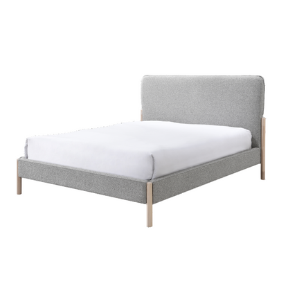 Gray upholstered bed with white mattress on a white background