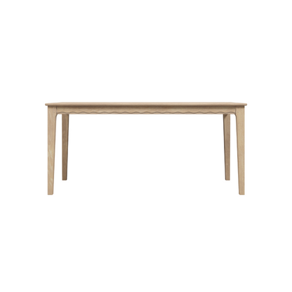 A rectangular oak dining table with a washed finish and visible wood grain, having a minimalist design with simple legs.