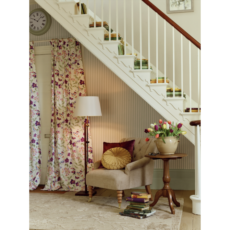 Nestled staircase with a chair, lamp, and decorative items in a home interior.