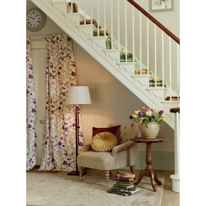 Nestled staircase with a chair, lamp, and decorative items in a home interior.